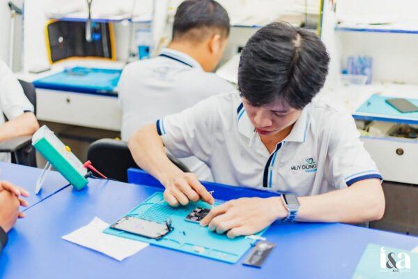 kỹ thuật viên tại Huy Dũng Mobile đang kiểm tra và xử lý linh kiện điện thoại