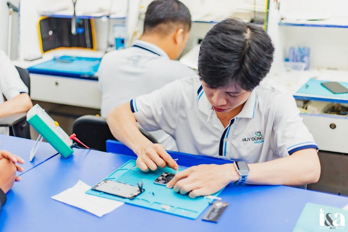 kỹ thuật viên tại Huy Dũng Mobile đang kiểm tra và xử lý linh kiện điện thoại