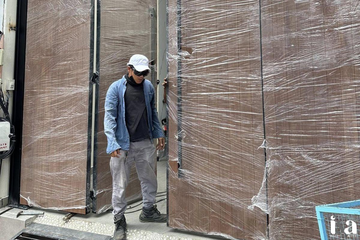 nhân viên đang lắp đặt cổng gỗ của Tâm Gỗ
