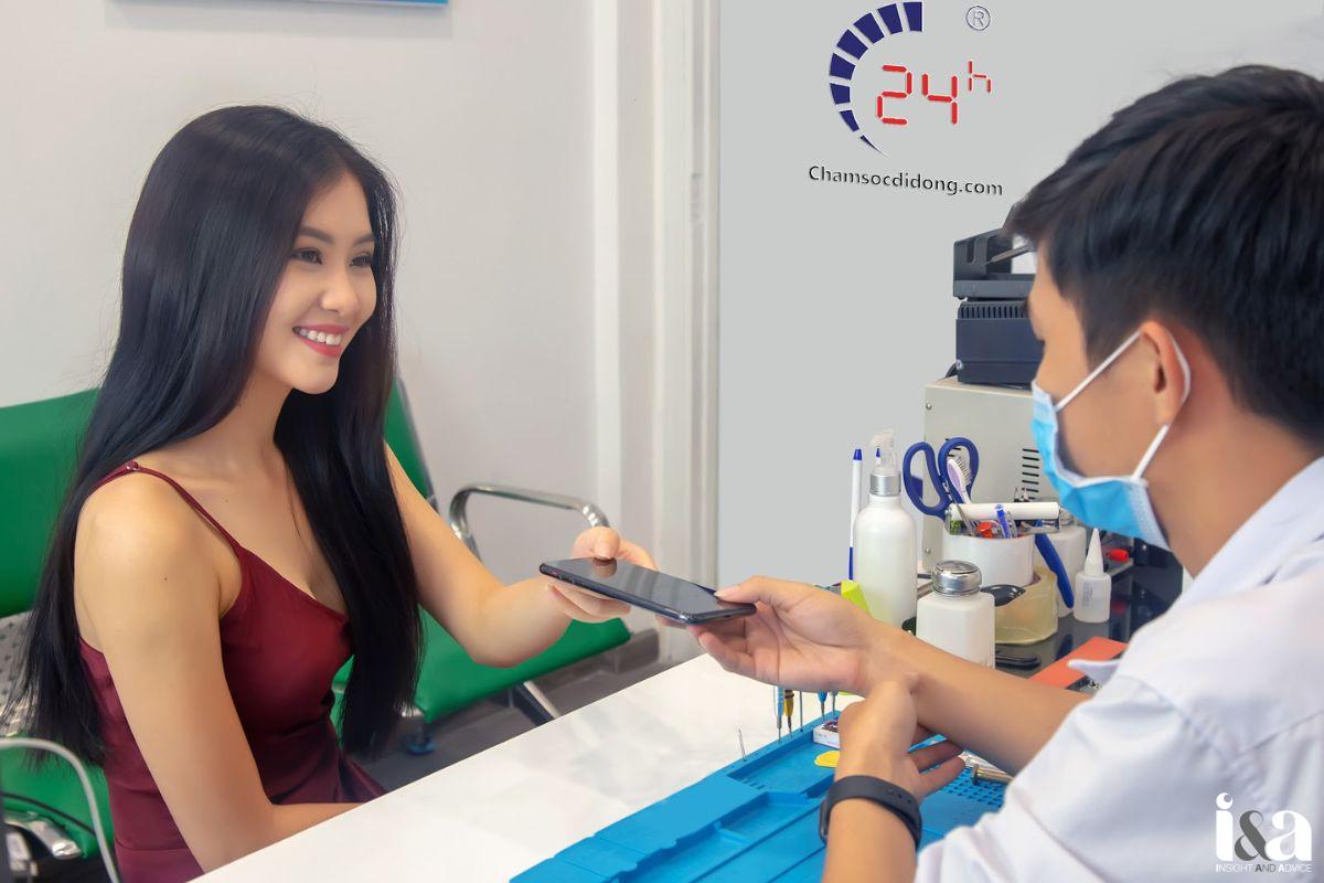 Nhân viên Bệnh Viện Điện Thoại Laptop 24h trao điện thoại cho khách hàng 